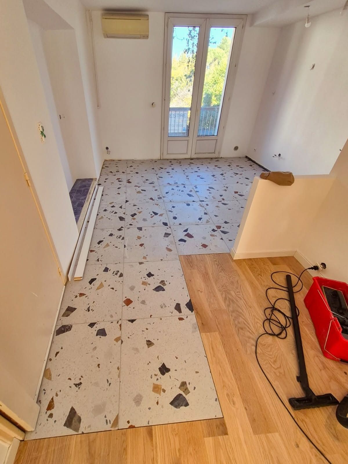 Le sol terminé : carrelage effet terrazzo raccordé au parquet, joints réalisés