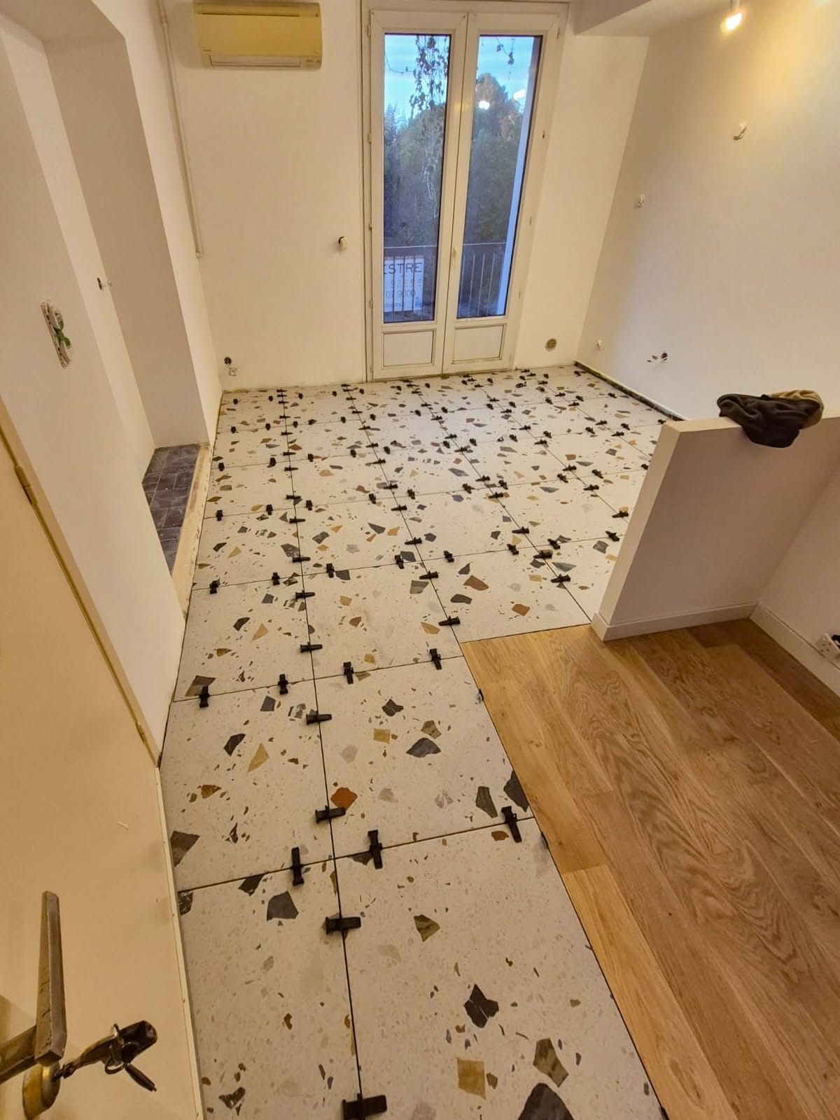Pose d'un carrelage effet terrazzo : dalles maintenues par des croisillons autonivelants