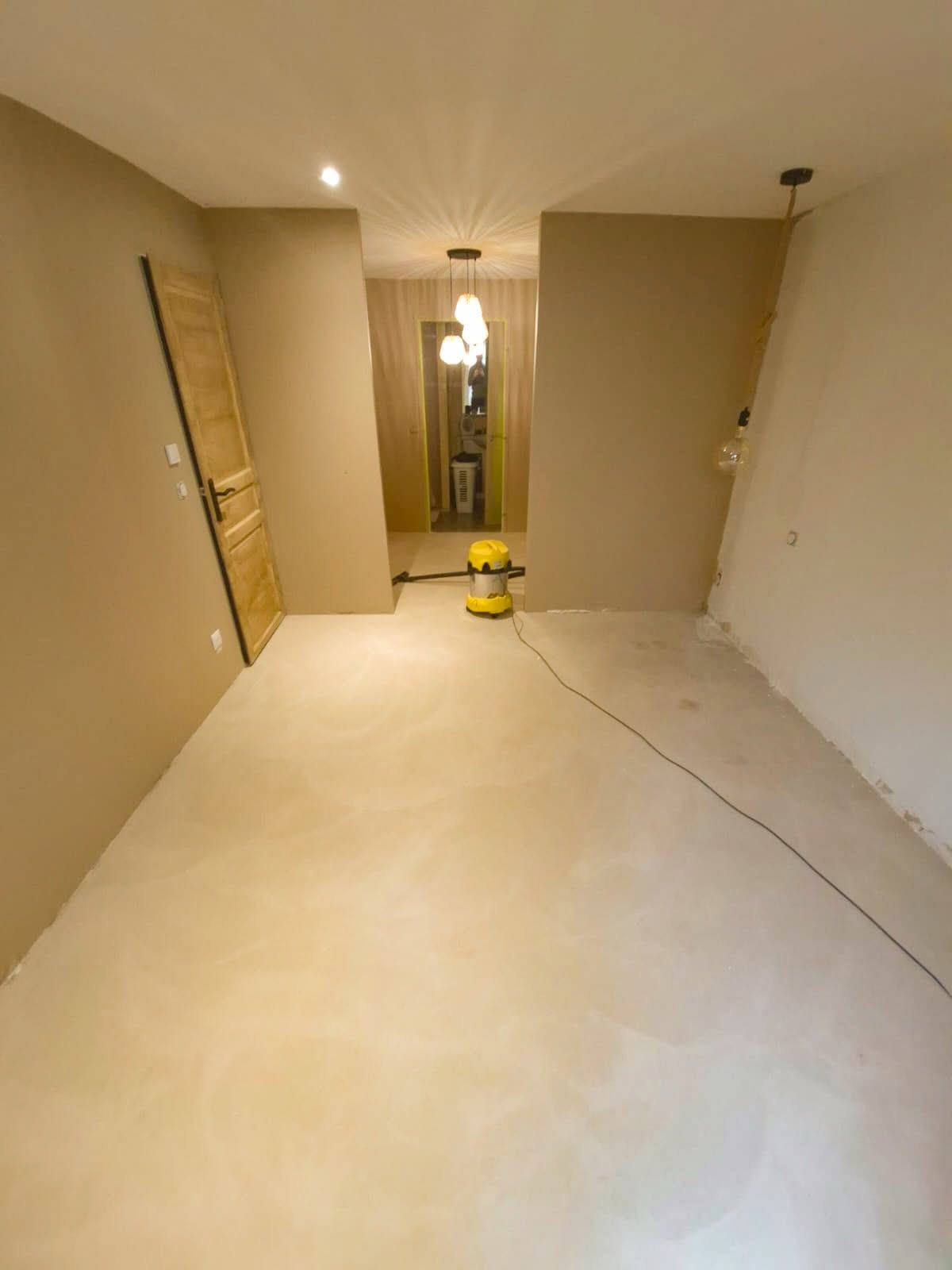 Pièce entièrement revêtue d'un enduit décoratif clair, du sol jusqu'au plafond