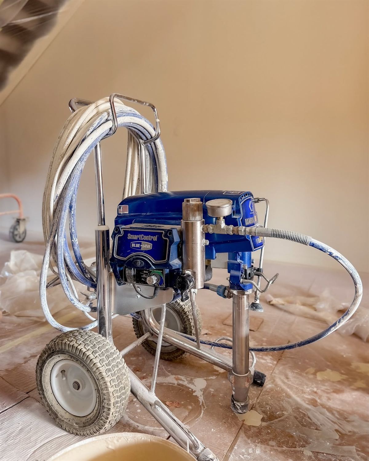 Station de peinture airless installée dans une pièce entièrement protégée par des bâches