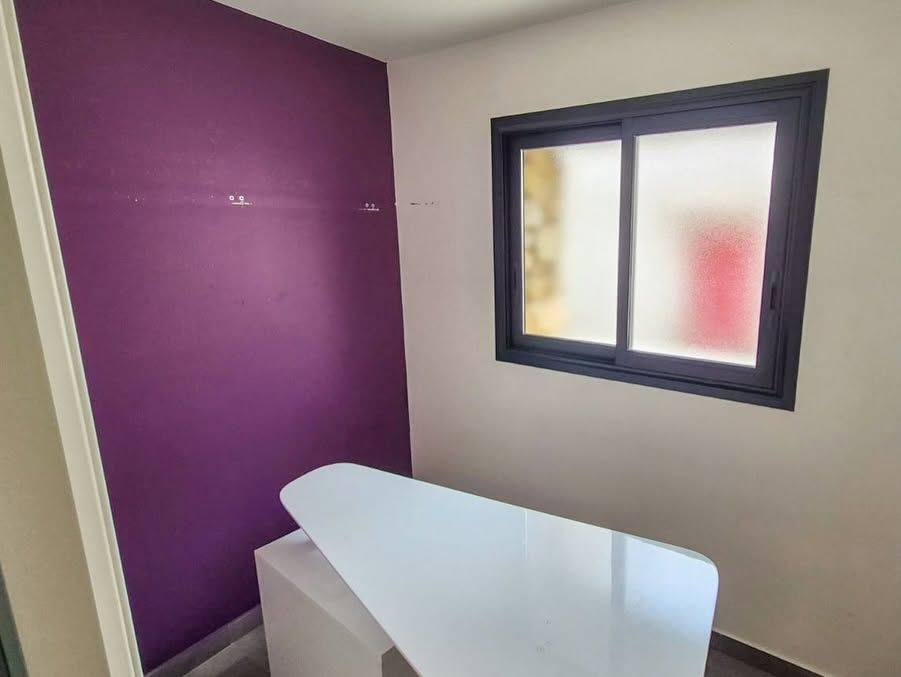 Mur peint dans un violet profond dans une salle de bains, avec une découpe nette sur le mur blanc attenant