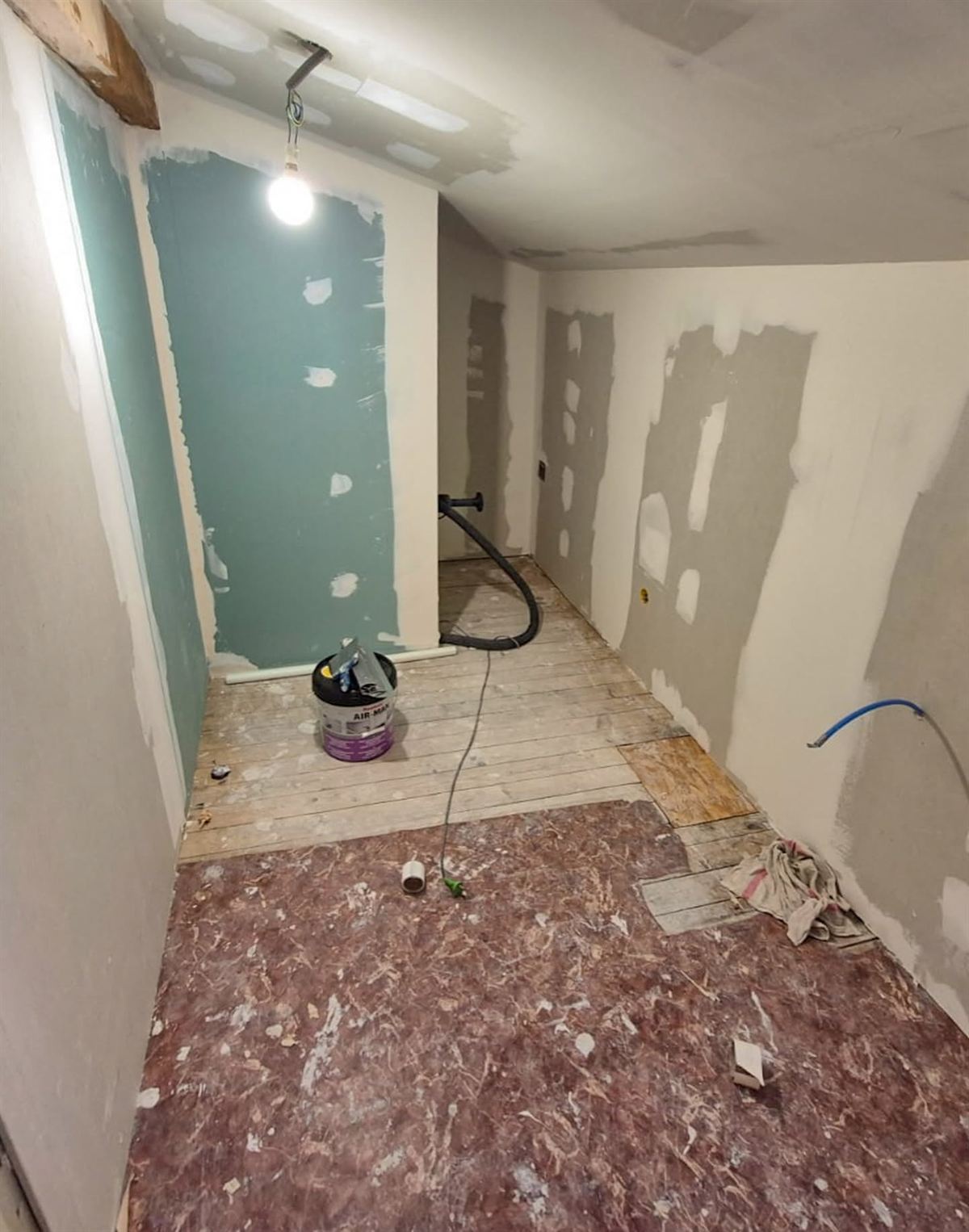 Pièce en cours de placo : plaque hydrofuge vert d'eau en fond de niche, cloisons et plafond dont les bandes et les têtes de vis sont enduites